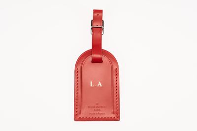 Tag portanome per bagaglio in pelle rosso con iniziali L.A., dettagli in metallo