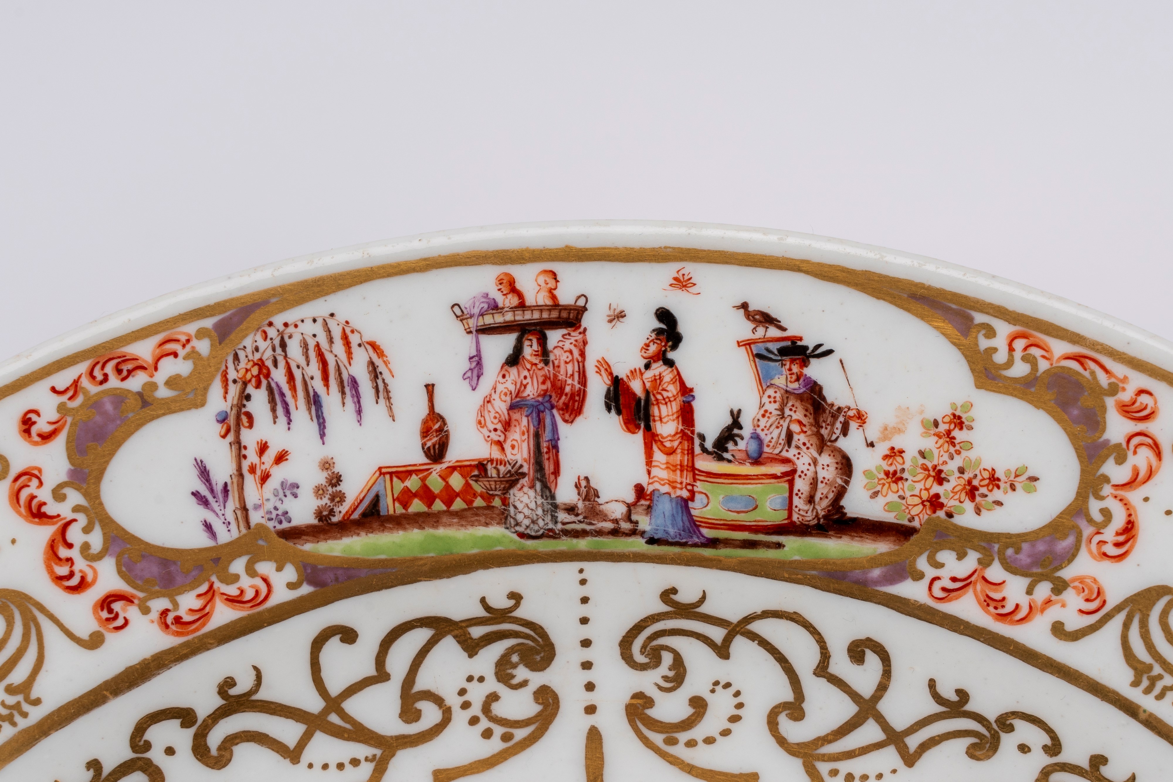 Meissen, Piatto in porcellana decorata con dorature ad arabeschi e policromia (medaglione central...