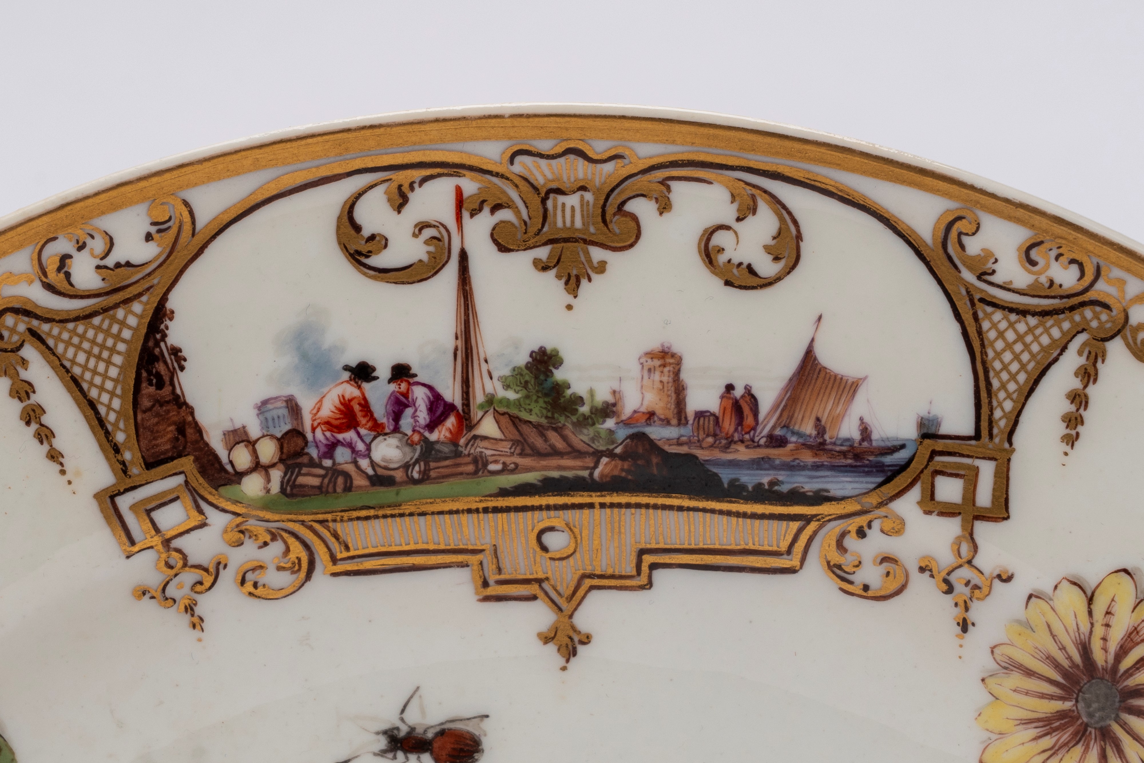 Meissen (attrib.), Piatto in porcellana bianca con scena portuale entro riserve dorate e policrom...