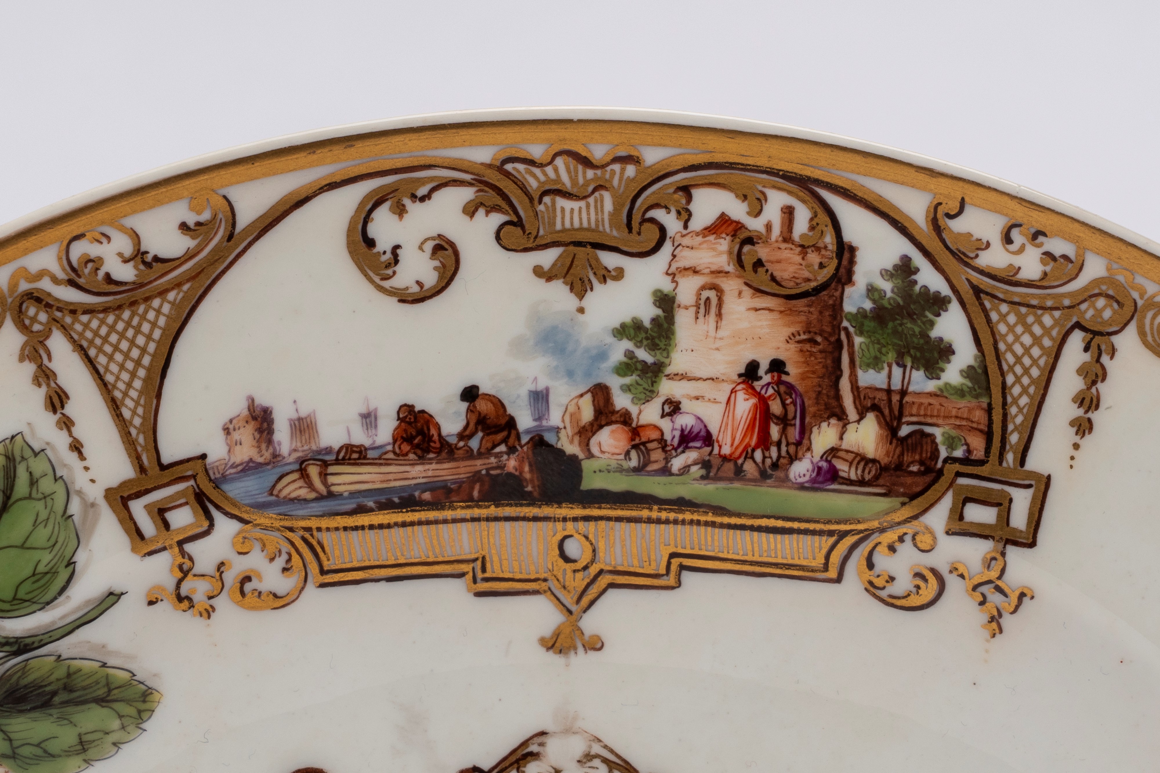 Meissen (attrib.), Piatto in porcellana bianca con scena portuale entro riserve dorate e policrom...