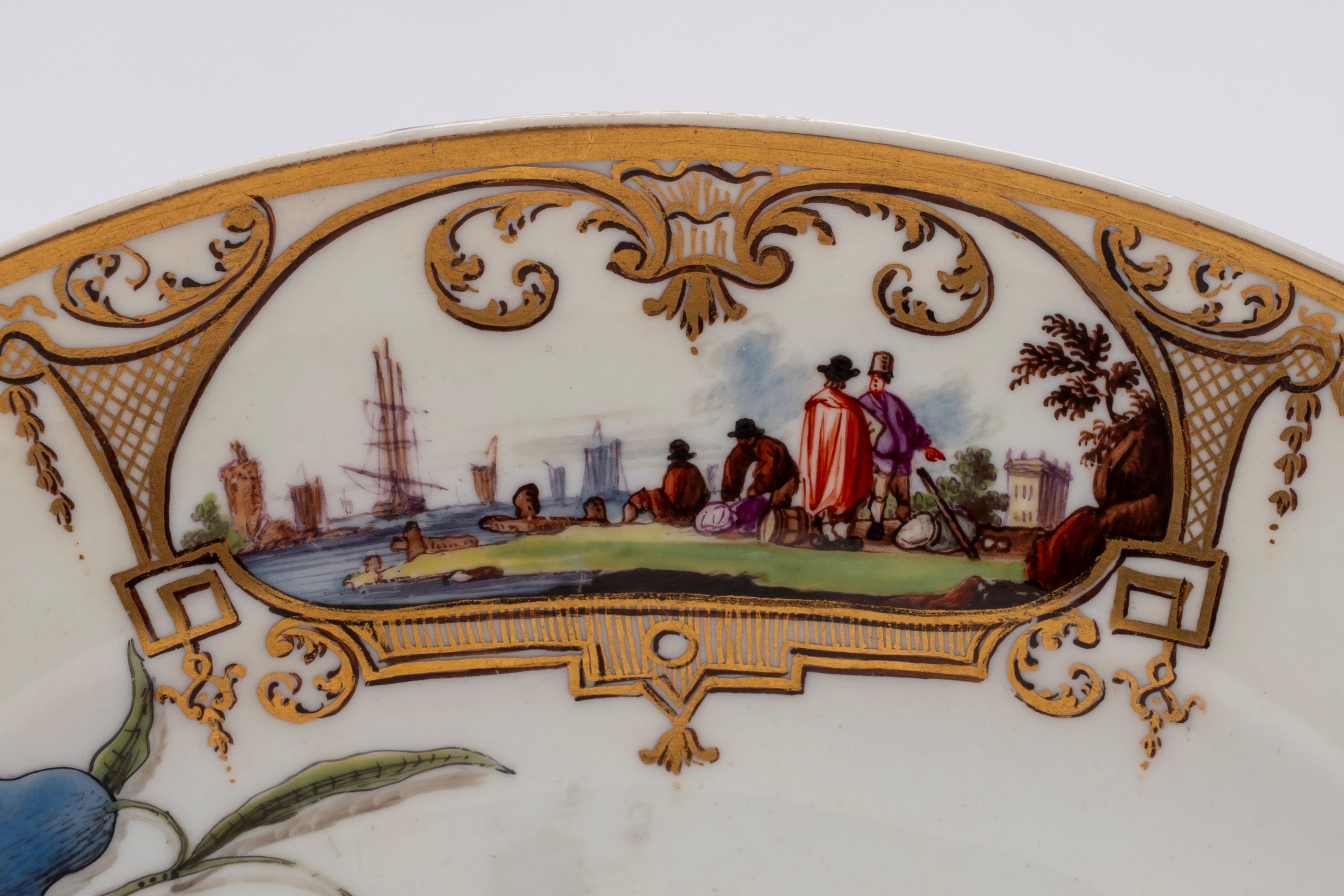 Meissen (attrib.), Piatto in porcellana bianca con scena portuale entro riserve dorate e policrom...