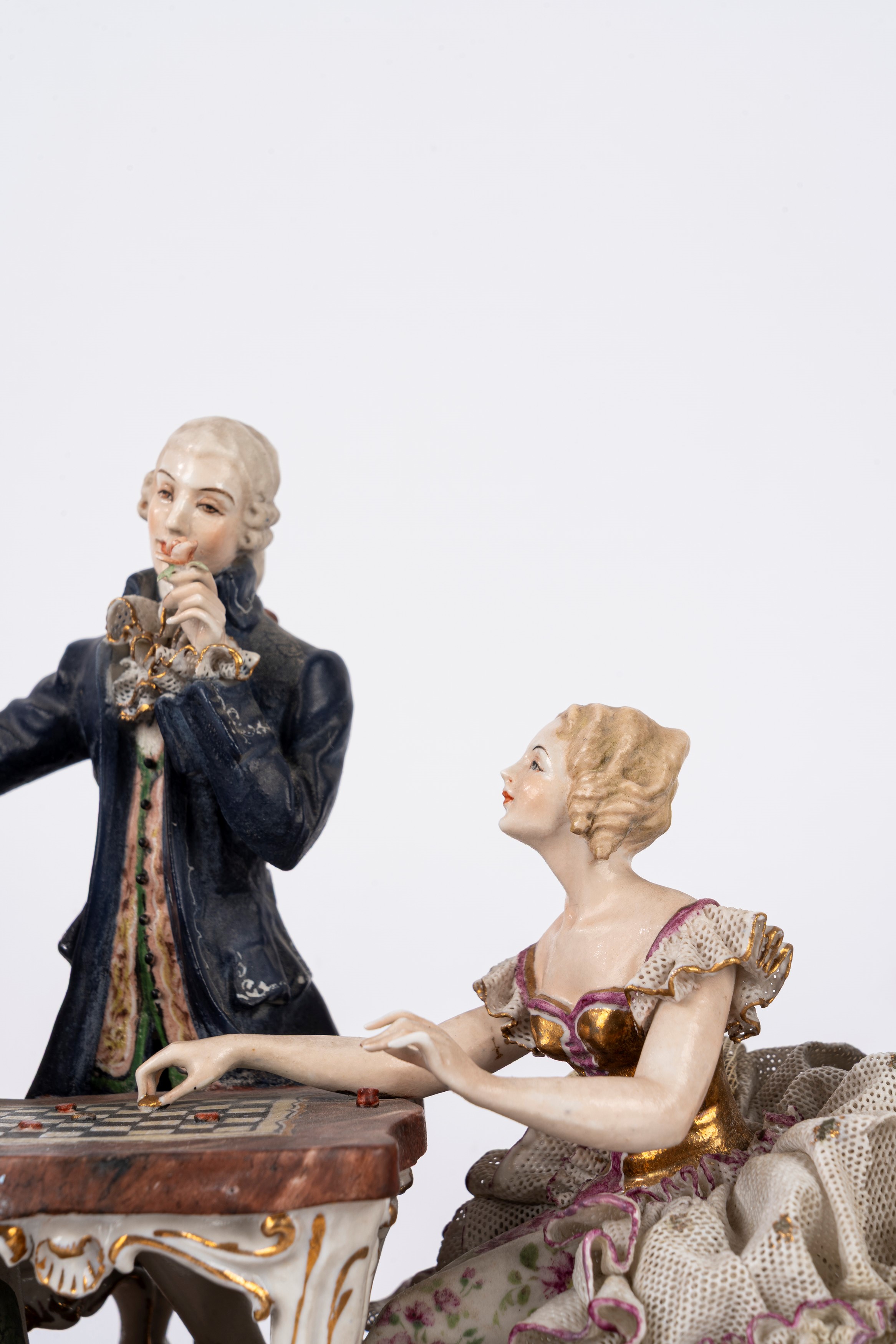 Gruppo scultoreo, porcellana policroma raffigurante giocatori di dama, su base a rocaille