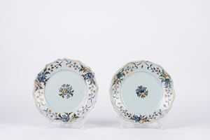 Coppia di piatti in maiolica policroma, decorati a motivi floreali