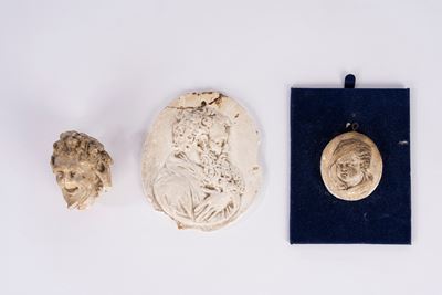 Lotto composto da tre piccole sculture in gesso, bassorilievi ovali e frammento di testa di satir...