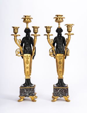 Coppia di candelabri in bronzo dorato e patinato su basi in marmo. Secolo XIX