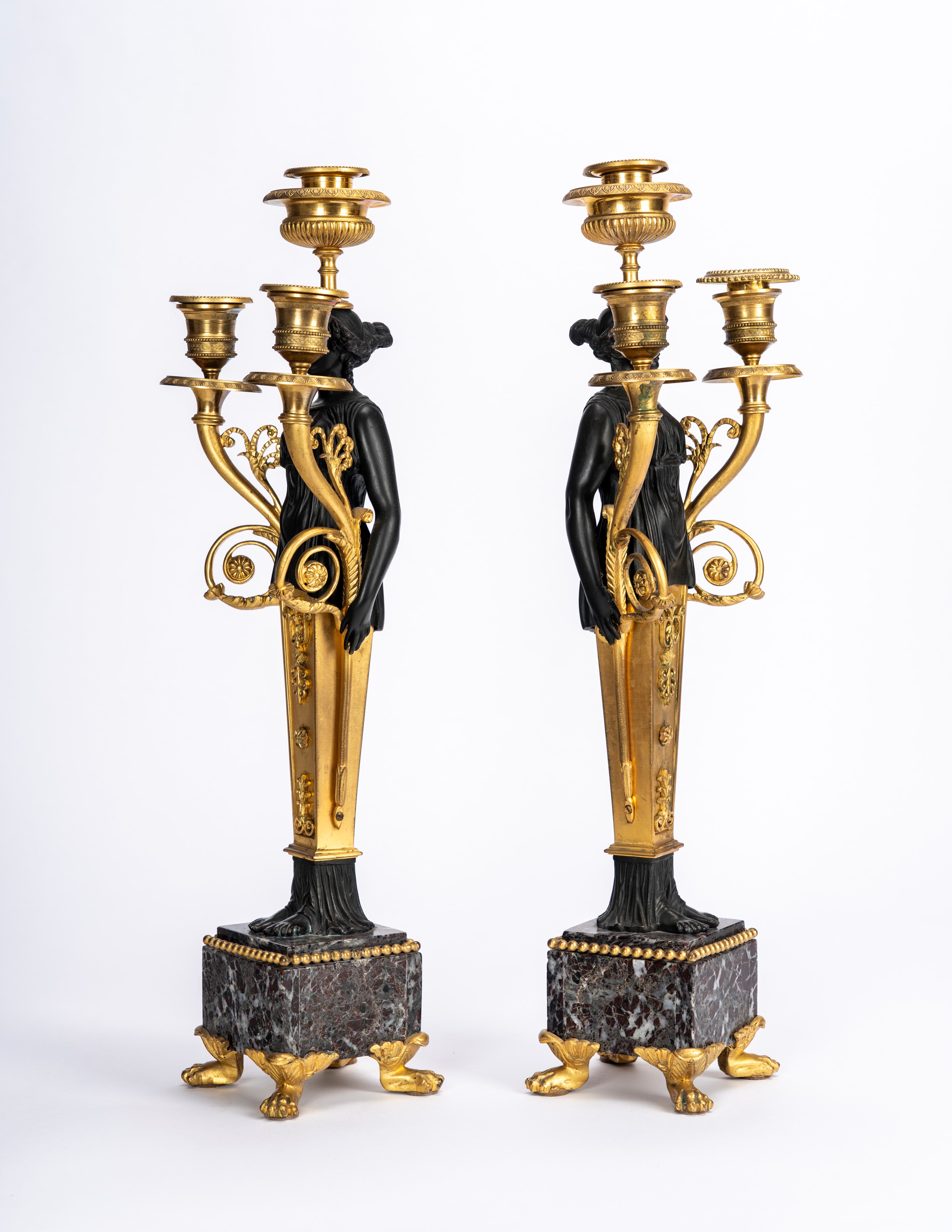 Secolo XIX, Coppia di candelabri in bronzo dorato e patinato con basi in marmo