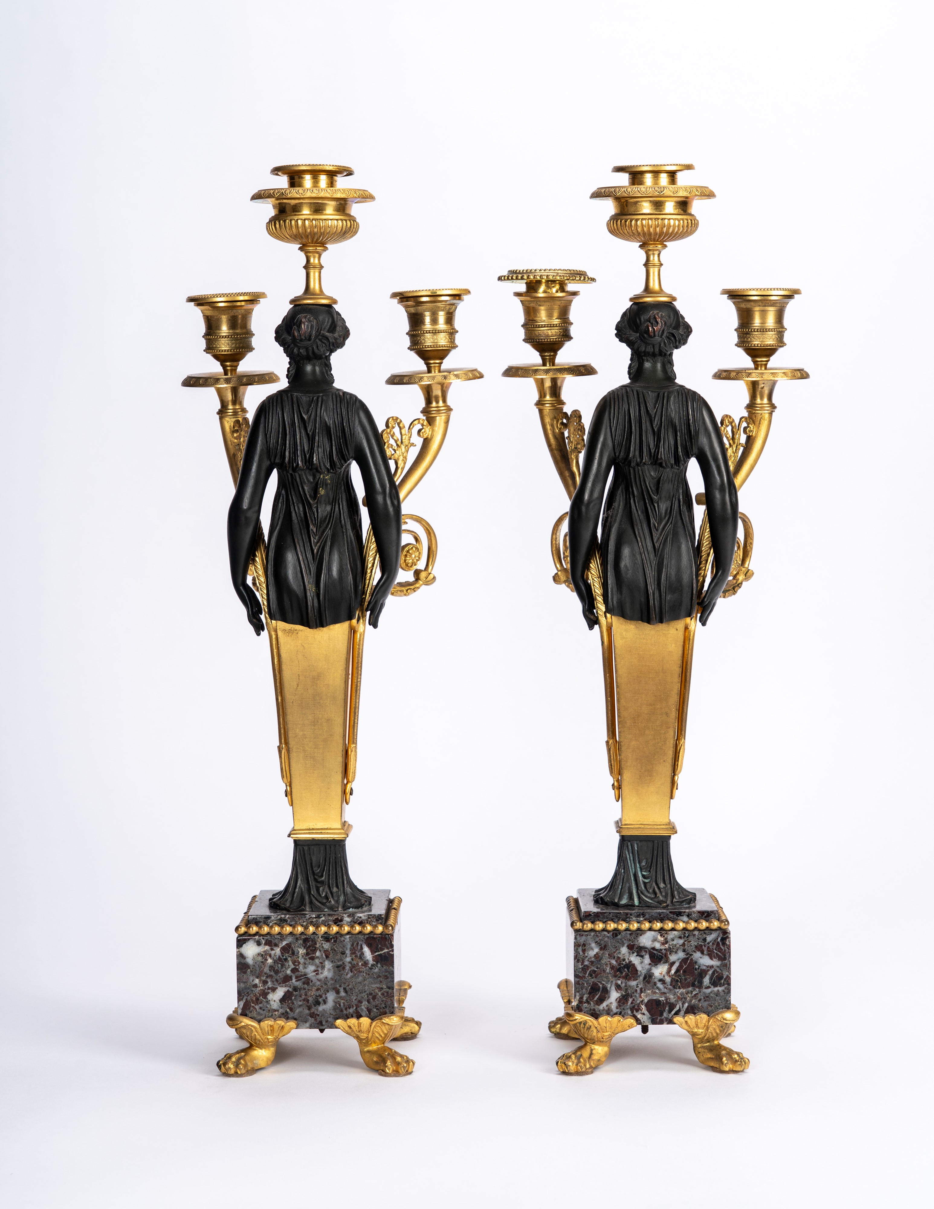 Secolo XIX, Coppia di candelabri in bronzo dorato e patinato con basi in marmo