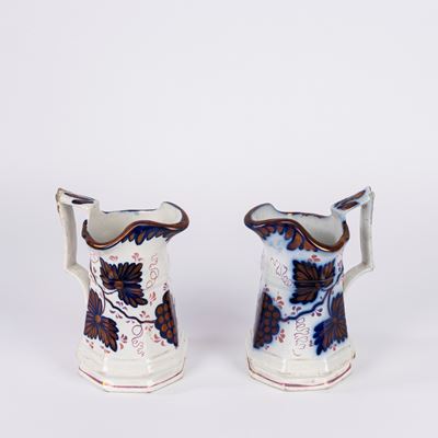 Coppia di brocche in ceramica bianca, decorate a lustro con tralci d’uva