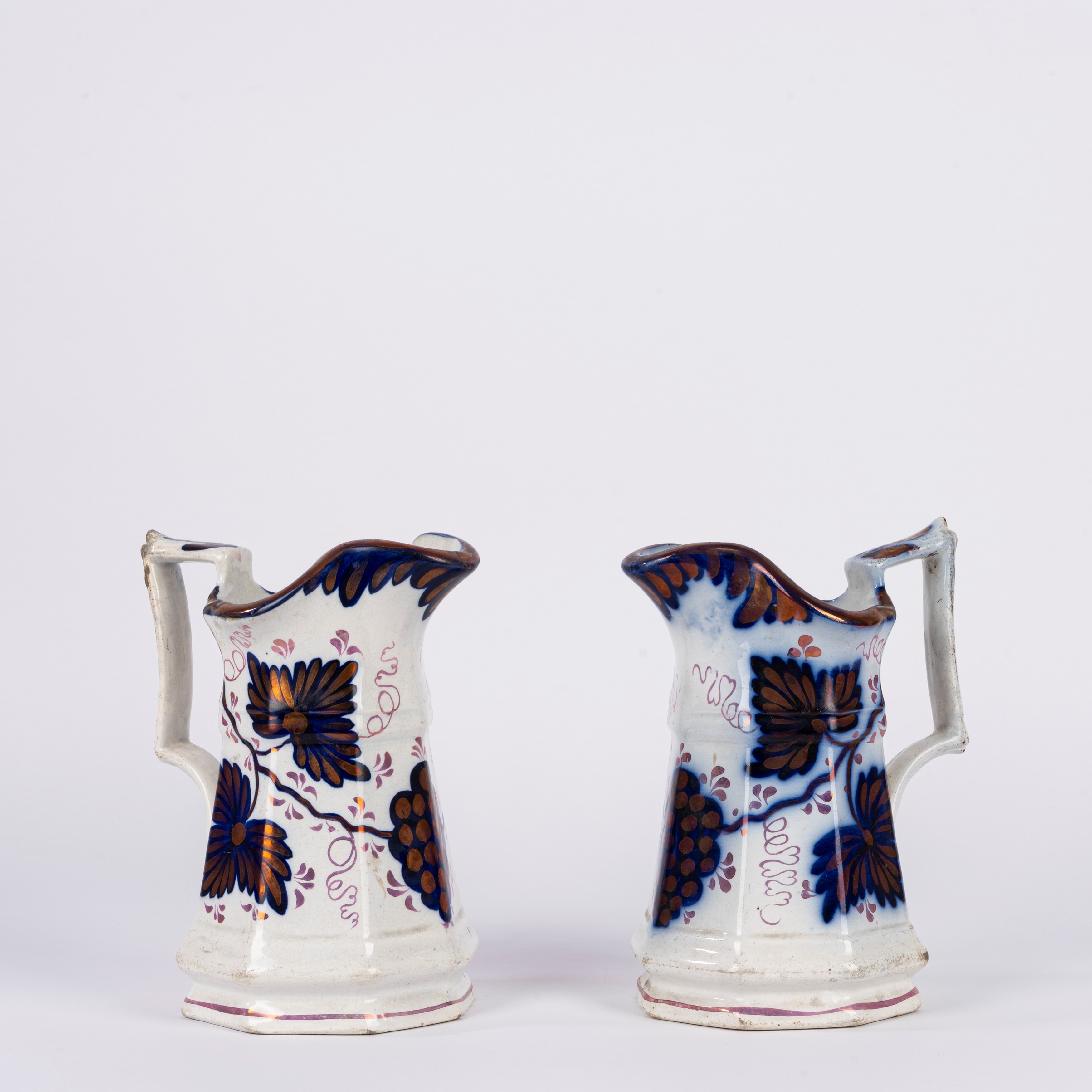 Coppia di brocche in ceramica bianca, decorate a lustro con tralci d’uva