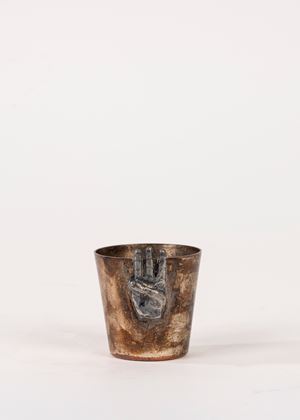 Small metal cup with applied hand-shaped decoration