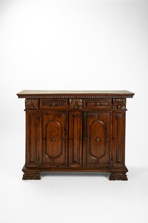 Credenza in noce a due ante e due cassetti pannellati. Secolo XVII.