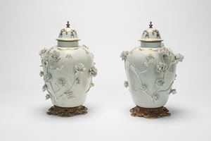 Two white and gold porcelain vases decorated in relief with flowering branches. 19th century.