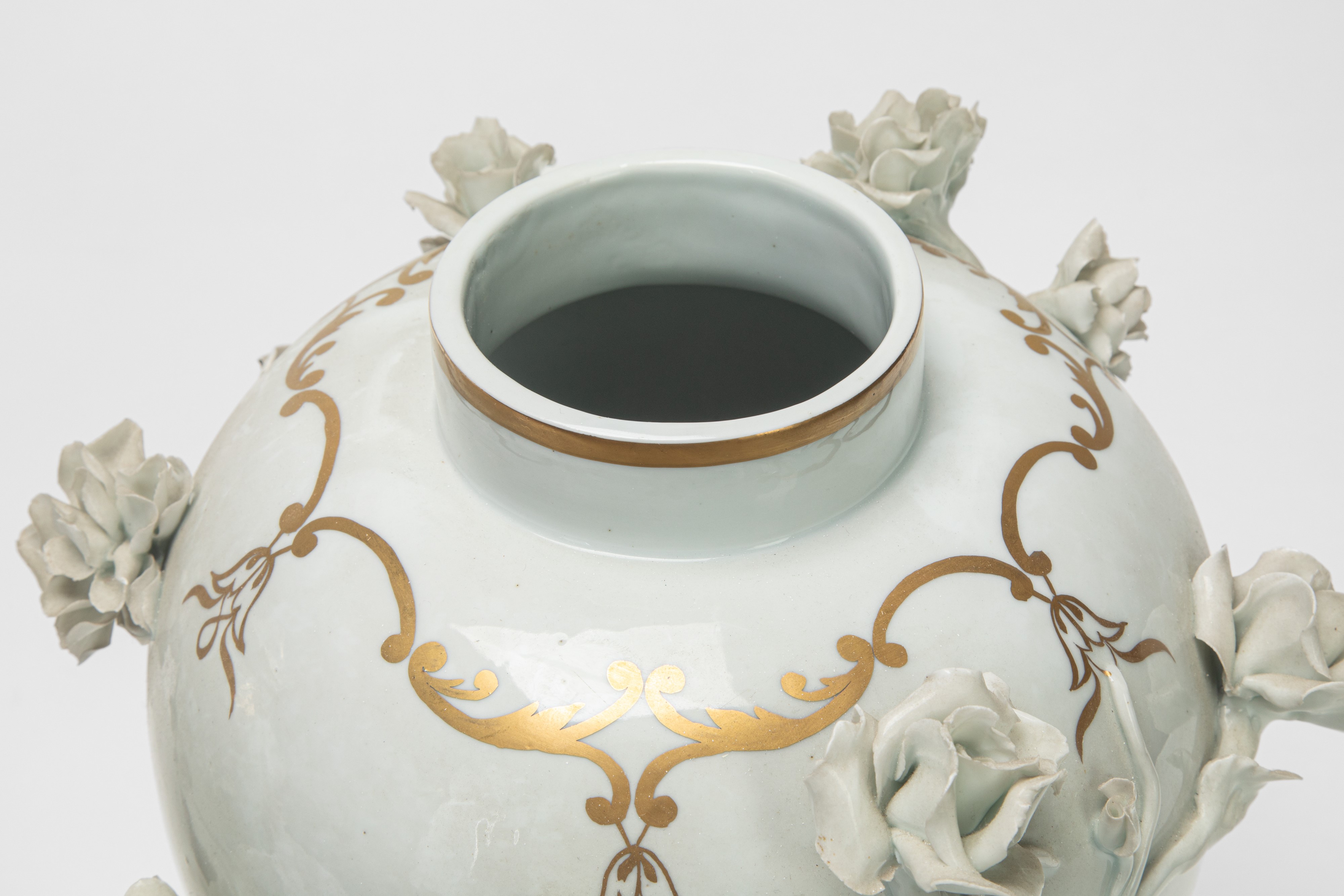 Due potiche in porcellana bianca e dorata con decorazione a rilievo, basi in bronzo dorato (XIX s...