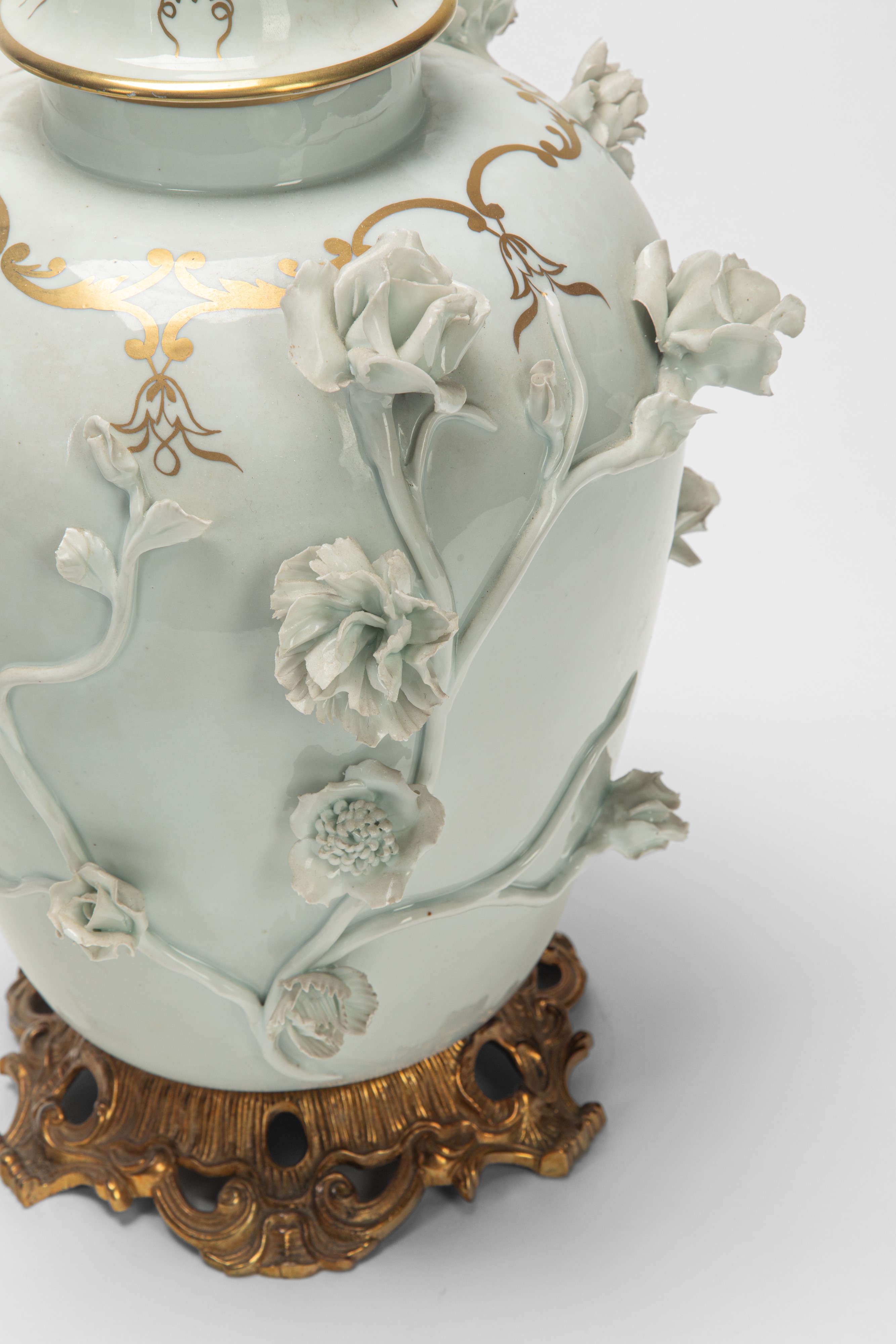 Due potiche in porcellana bianca e dorata con decorazione a rilievo, basi in bronzo dorato (XIX s...