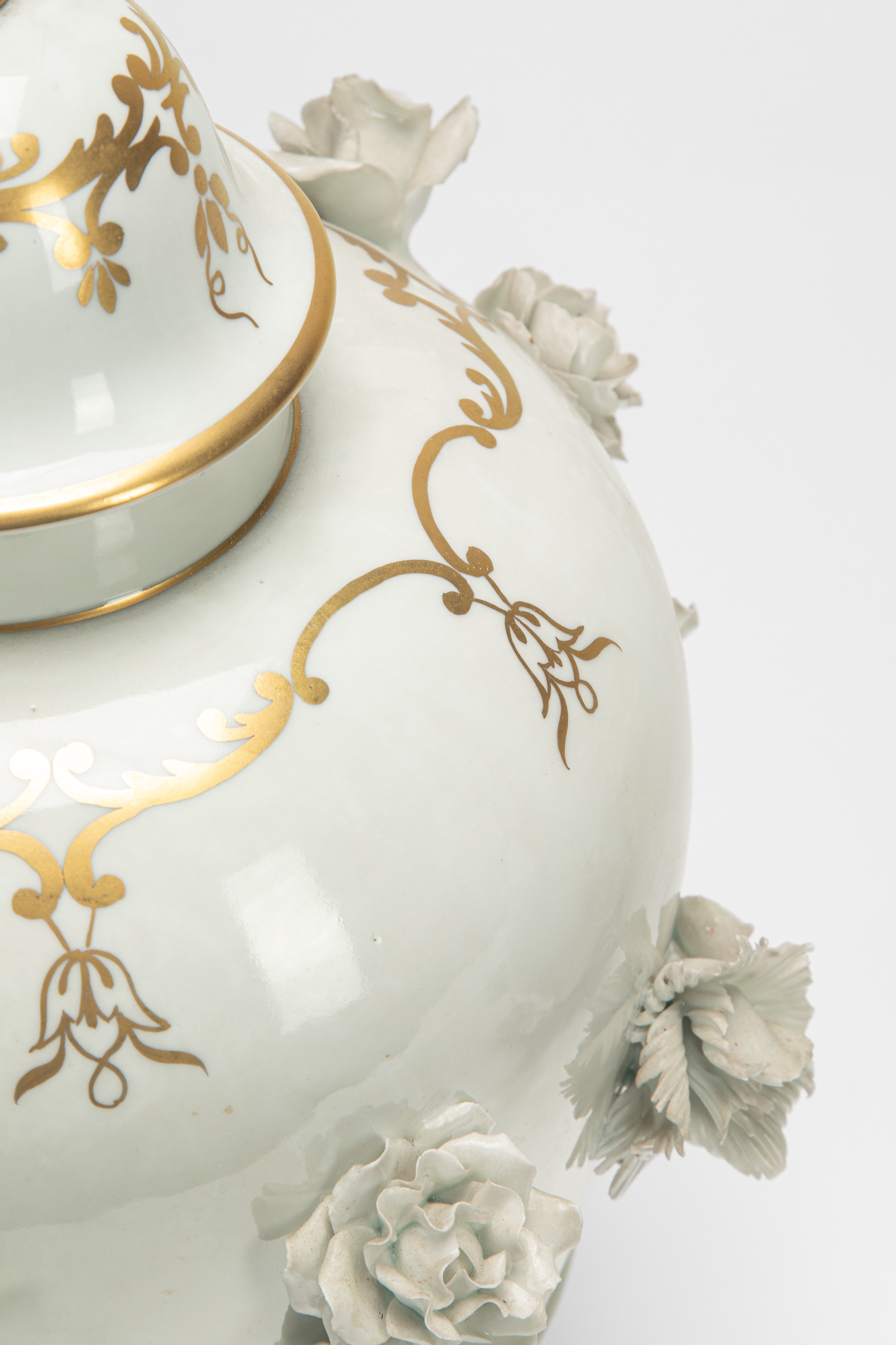 Due potiche in porcellana bianca e dorata con decorazione a rilievo, basi in bronzo dorato (XIX s...