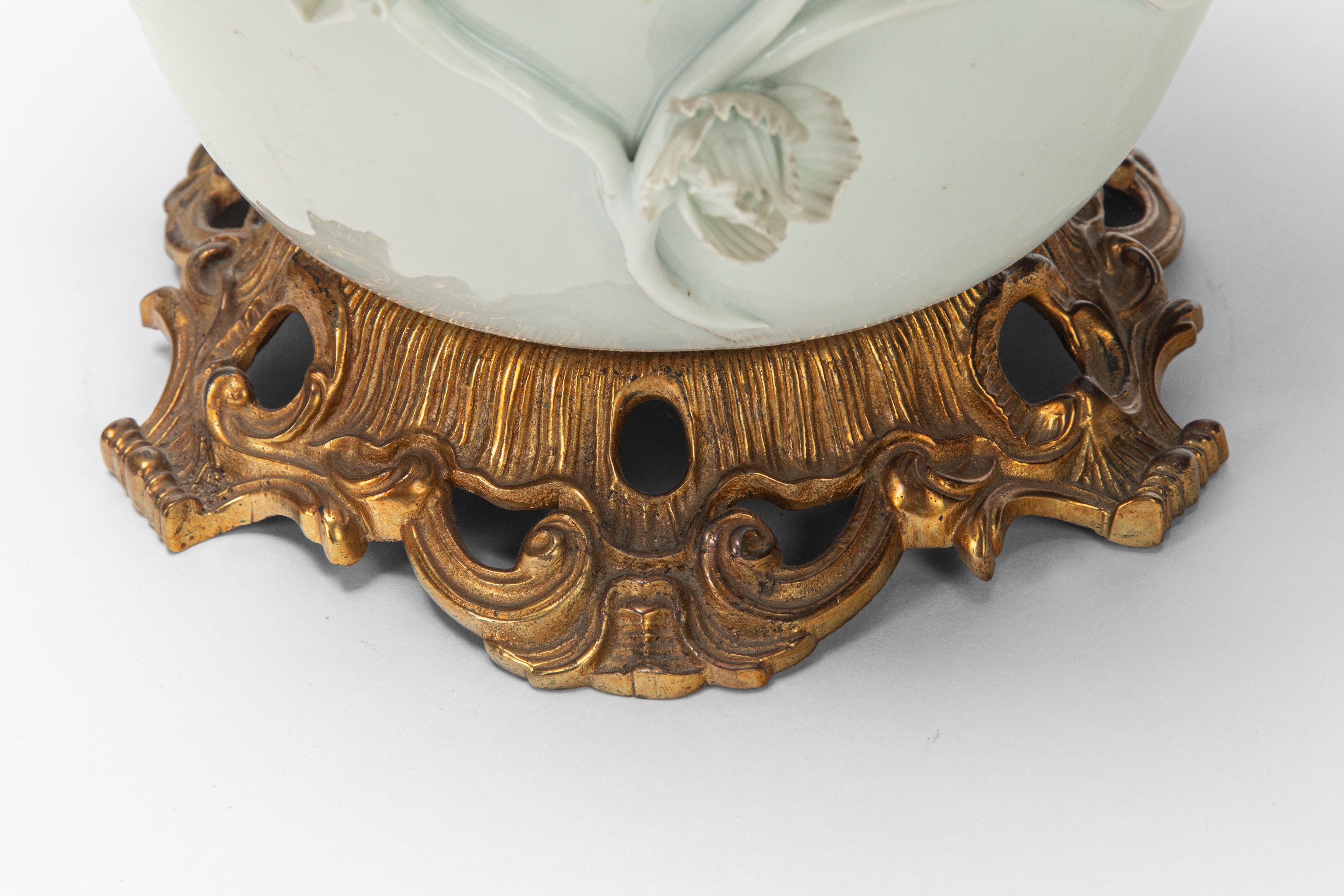 Due potiche in porcellana bianca e dorata con decorazione a rilievo, basi in bronzo dorato (XIX s...