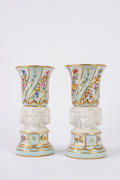 Coppia di vasi in porcellana con teste di putti in biscuit