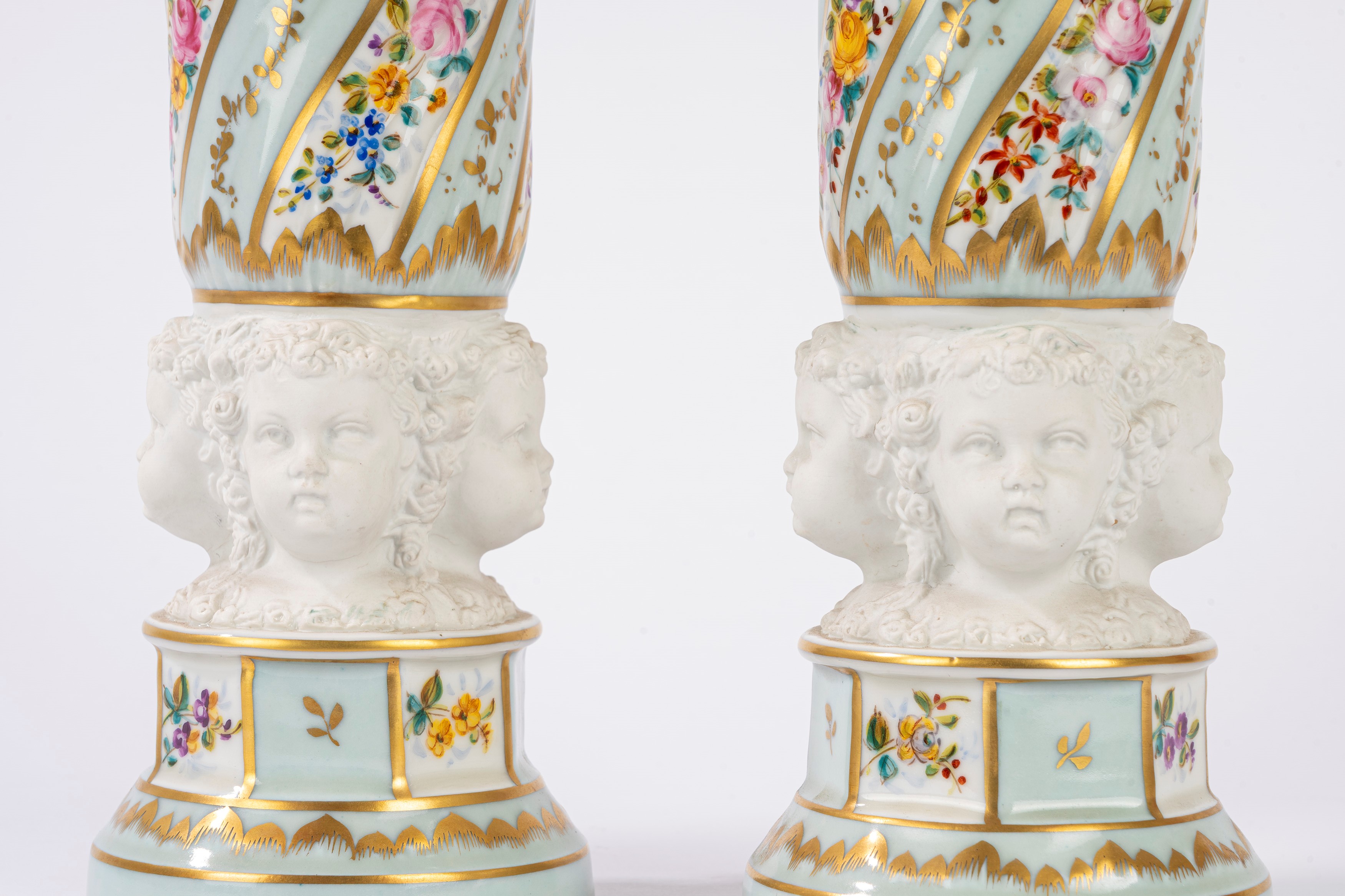 Coppia di vasi in porcellana con teste di putti in biscuit
