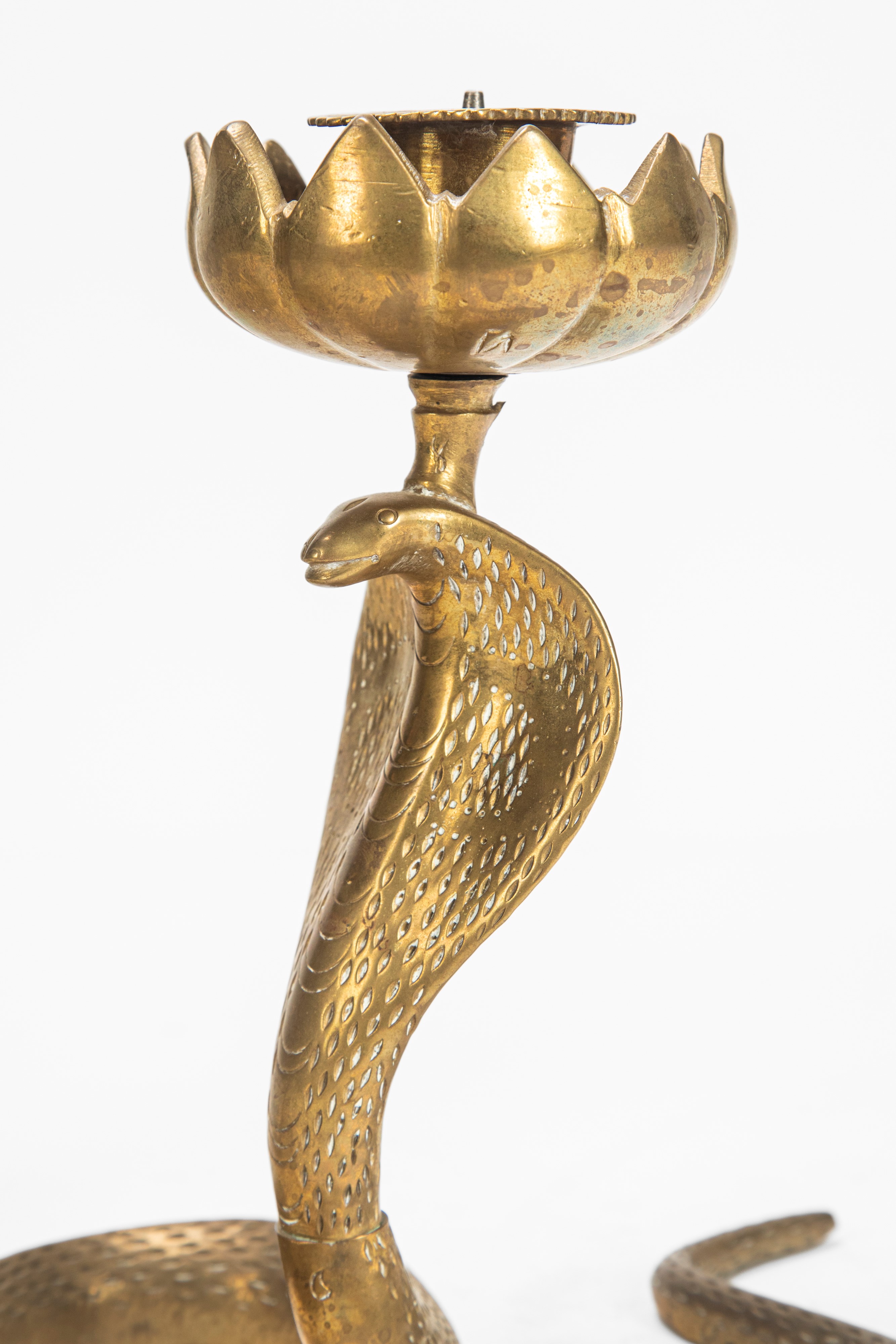 Coppia di candelieri a forma di cobra con portacandela a fiore di loto in metallo patinato