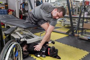 A Ukrainian soldier in Kyiv in 2026 undergoes rehabilitation while awaiting prosthetic limbs. In the photo, he is petting the first war-wounded dog fitted with bionic prosthetics