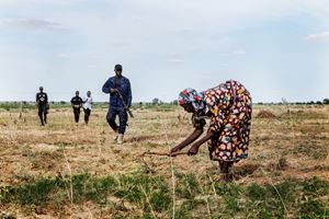 Maiduguri, Borno State. A female farmer on the outskirts of the city is protected by members of the Civilian Joint Task Force due to the constant kidnappings by Boko Haram and ISWAP