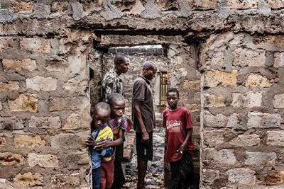 Some survivors from the village of Yelwa look inside the houses attacked by Fulani herders