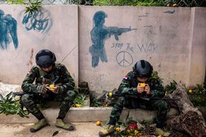 Two of General Mau&rsquo;s soldiers in Loikaw eat mangoes that fell after heavy shelling.