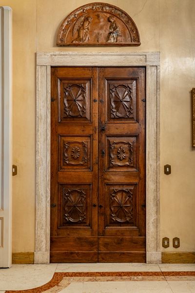 Piemonte, secolo XVII, Porta a due battenti in noce massello con pannelli intagliati a motivi geo...
