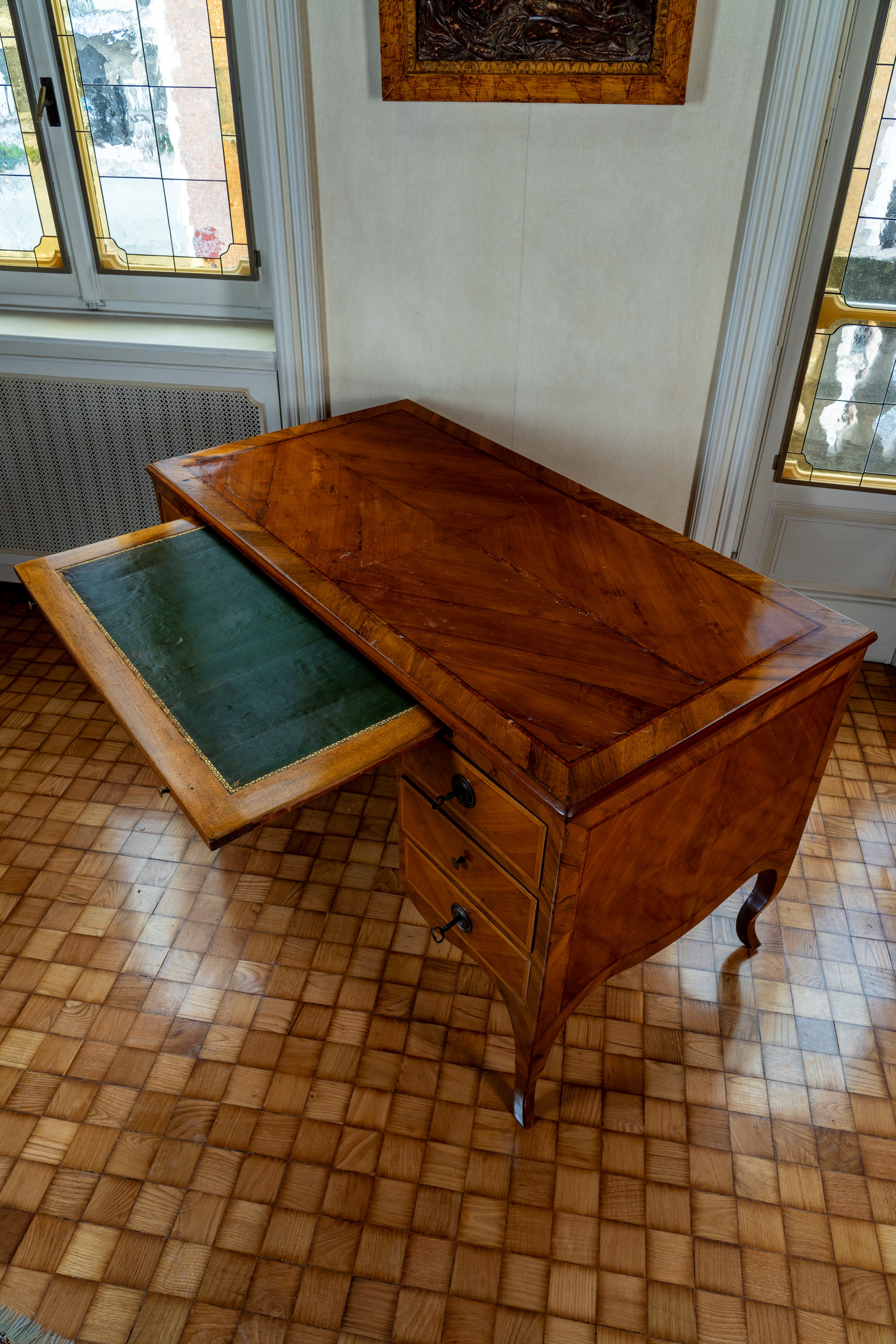 Scrivania da centro, filettata e lastronata in legni vari, con riserva in cuoio verde, secolo XVI...