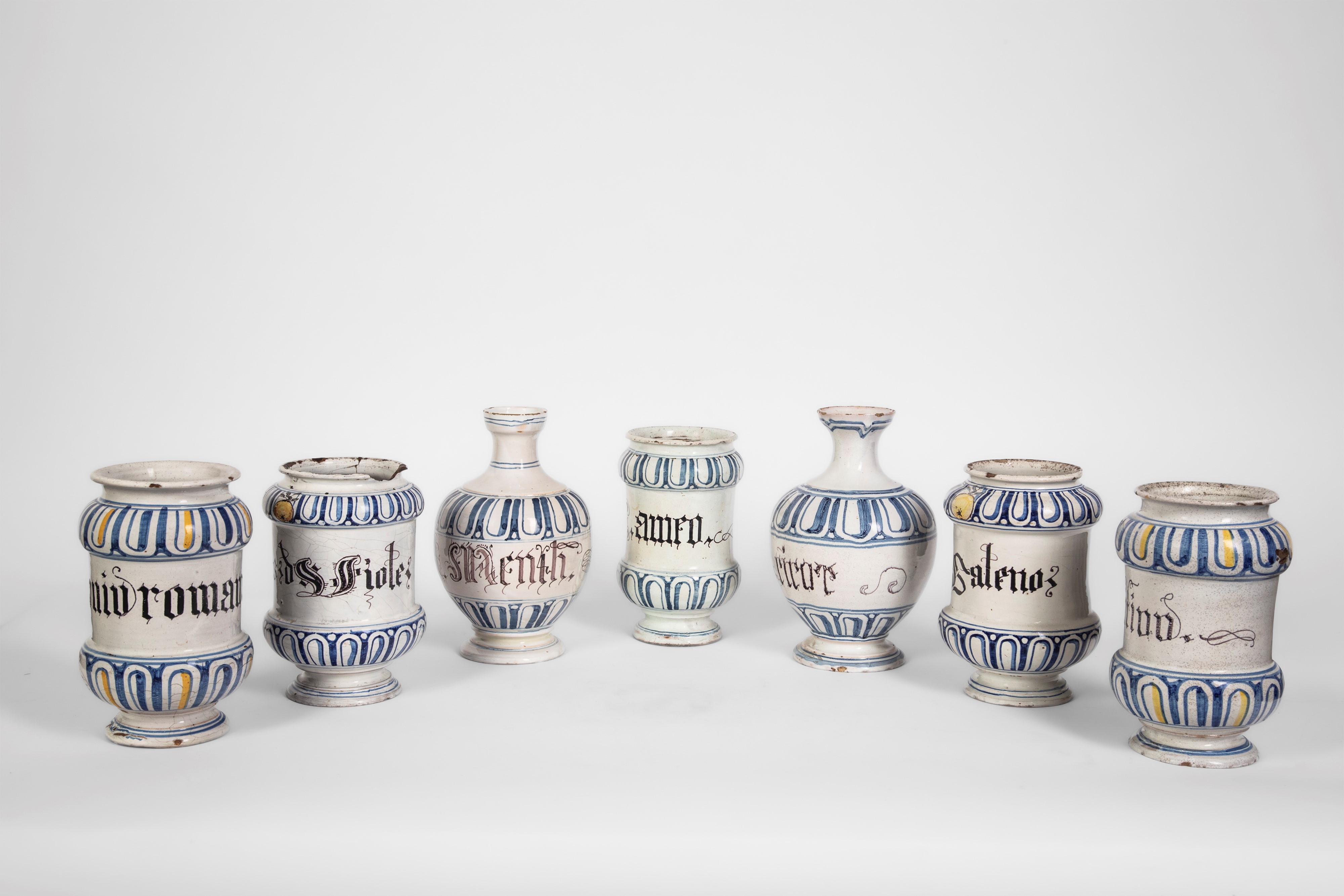 Italia settentrionale, XVIII secolo, Sette vasi da farmacia in maiolica policroma (albarelli e bo...