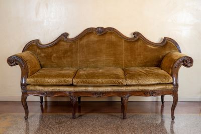 Divano a orecchioni in noce, intaglio decorativo, secolo XVIII