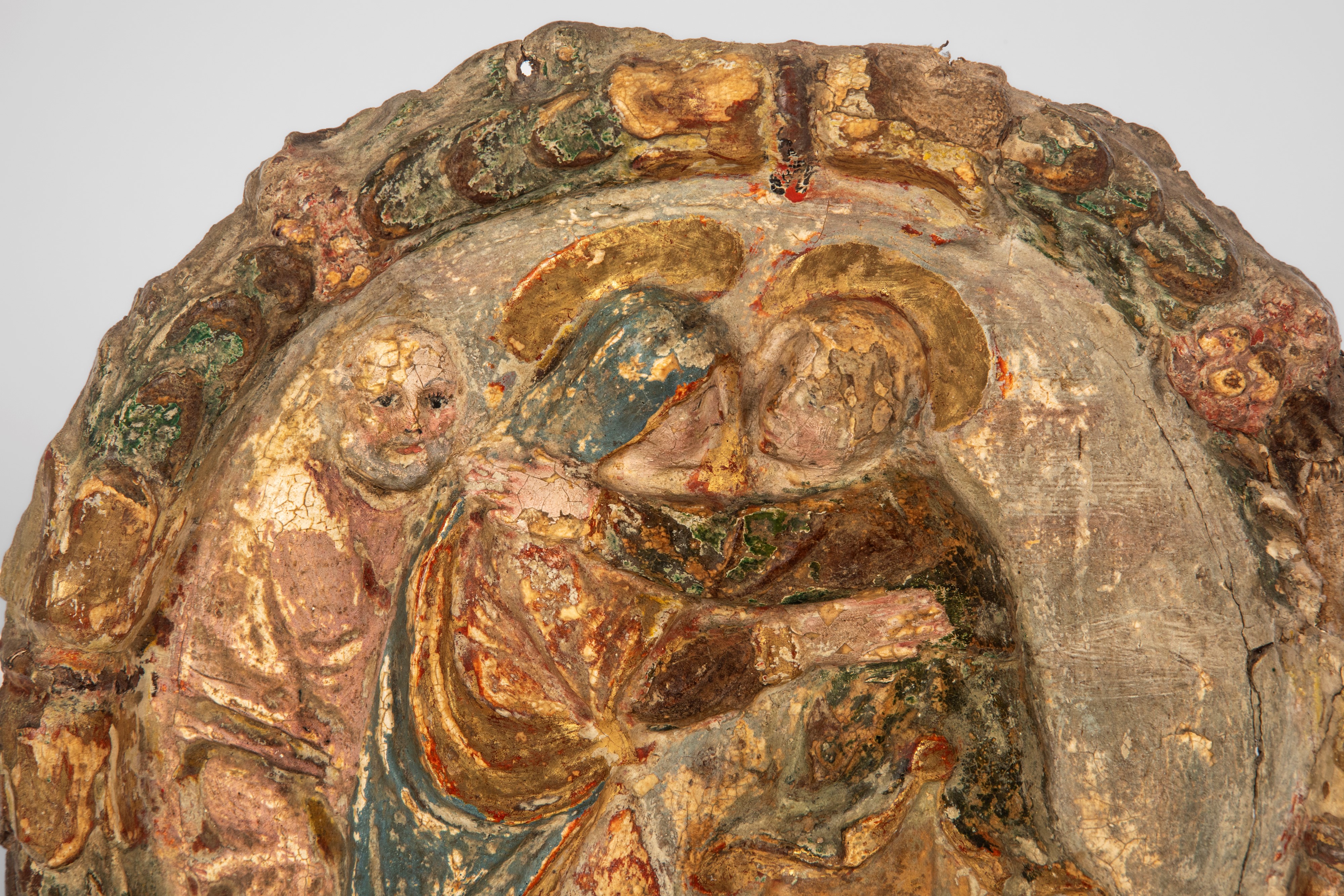 Coppia di medaglioni, cartapesta su tela calcata raffiguranti Visitazione e Natività entro ghirla...