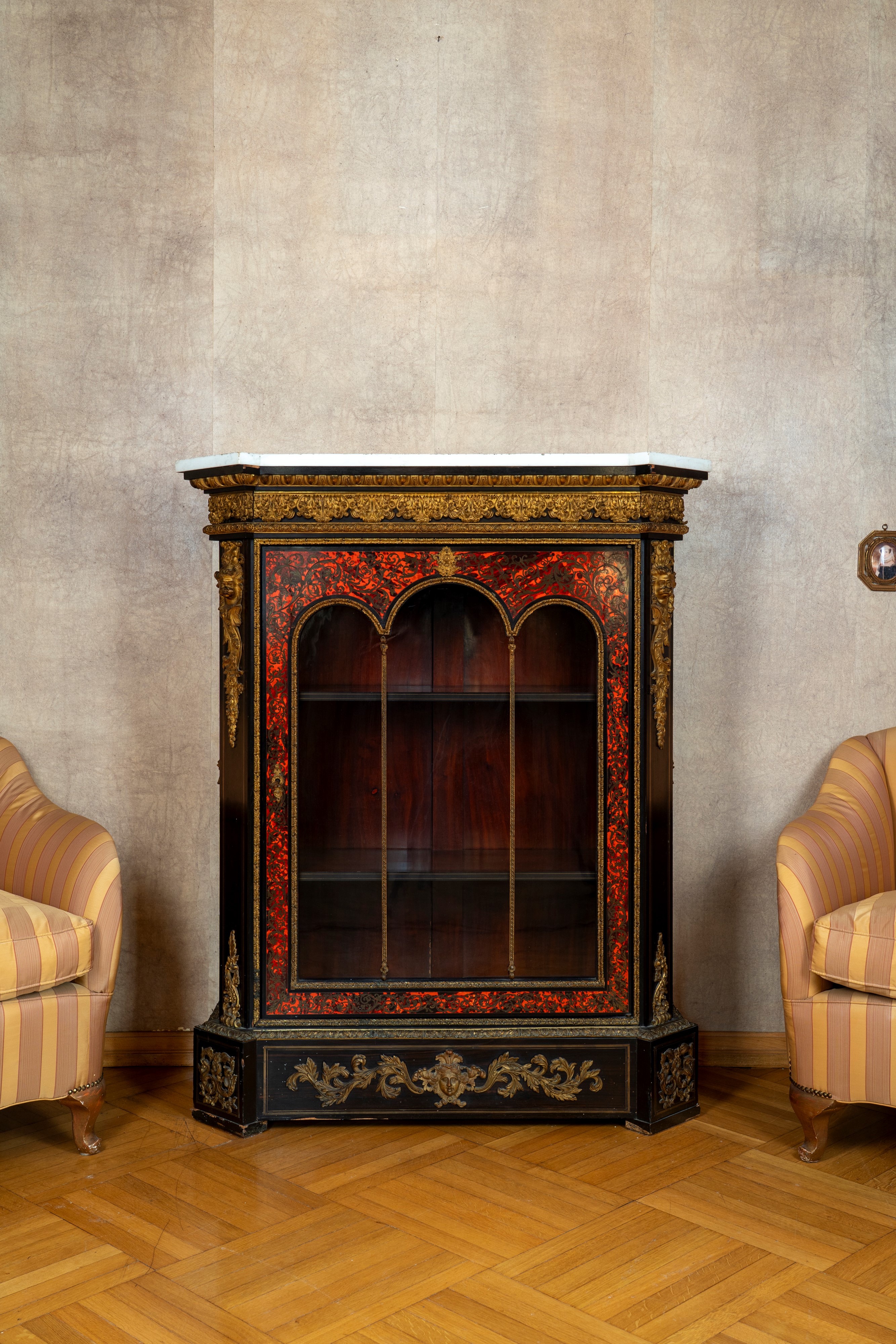 CREDENZA in stile Boulle, legno ebanizzato e intarsiato, con anta vetrata e piano in marmo bianco...
