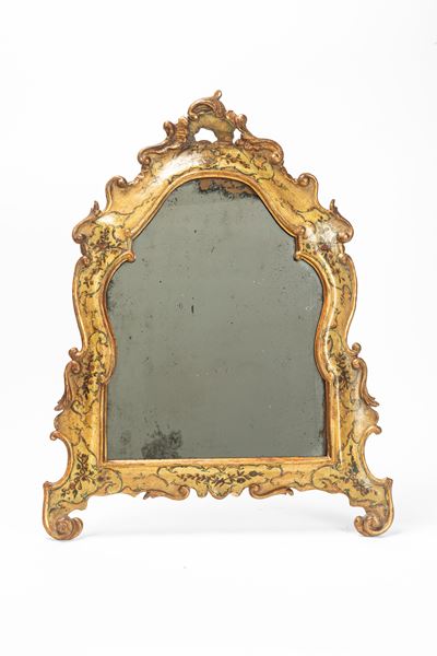 Specchiera in legno laccato e dorato, forma mossa, decorazioni vegetali e cimasa traforata (Venet...
