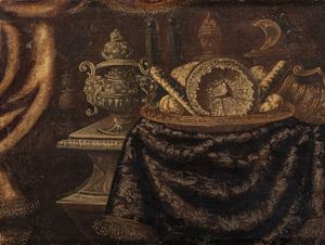 Dolci in un piatto, vasi ornamentali sbalzati, un orologio su una mensola in pietra scolpita e broccati