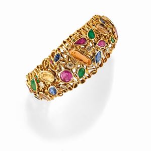 A 18K yellow gold, diamond, emerald, ruby, sapphire and colored gemstones bangle