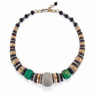 A silver, yellow gold, emerald, onyx and diamond necklace