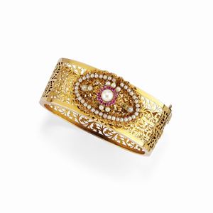 A 18K yellow gold, ruby and pearl bangle, defects