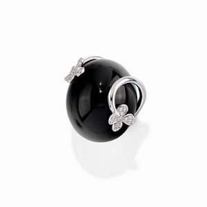  - A 18K white gold, onyx and diamond ring