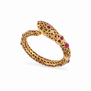 A guilted metal, ruby and emerald bangle