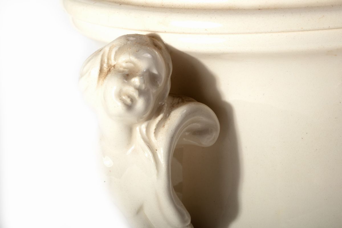Coppia di vasi biansati con testine di putti e cestino con vassoio, ceramica bianca, secolo XX