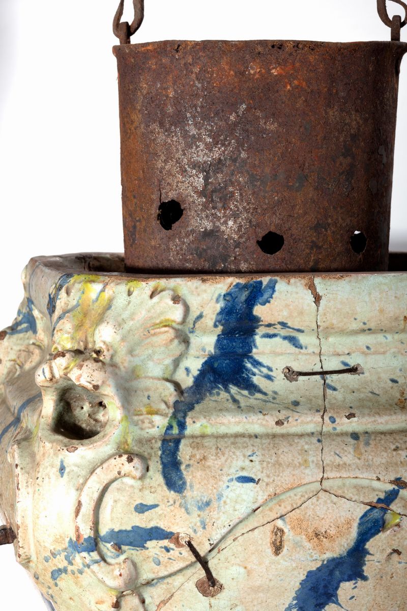 Stufetta in ceramica dipinta a finto marmo, bianca e blu, con mascheroni angolari