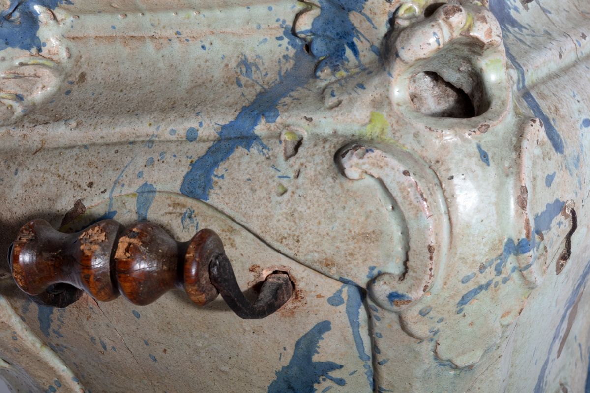 Stufetta in ceramica dipinta a finto marmo, bianca e blu, con mascheroni angolari
