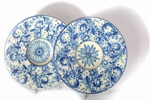 Two antique white and blue majolica plates with floral motifs, Delft manufacture