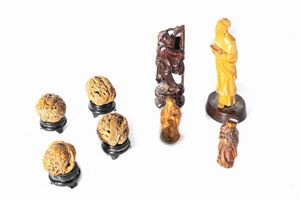 Lot consisting of four finely carved walnut shells and four small wooden sculptures depicting wise men, China 19th - 20th centuries
