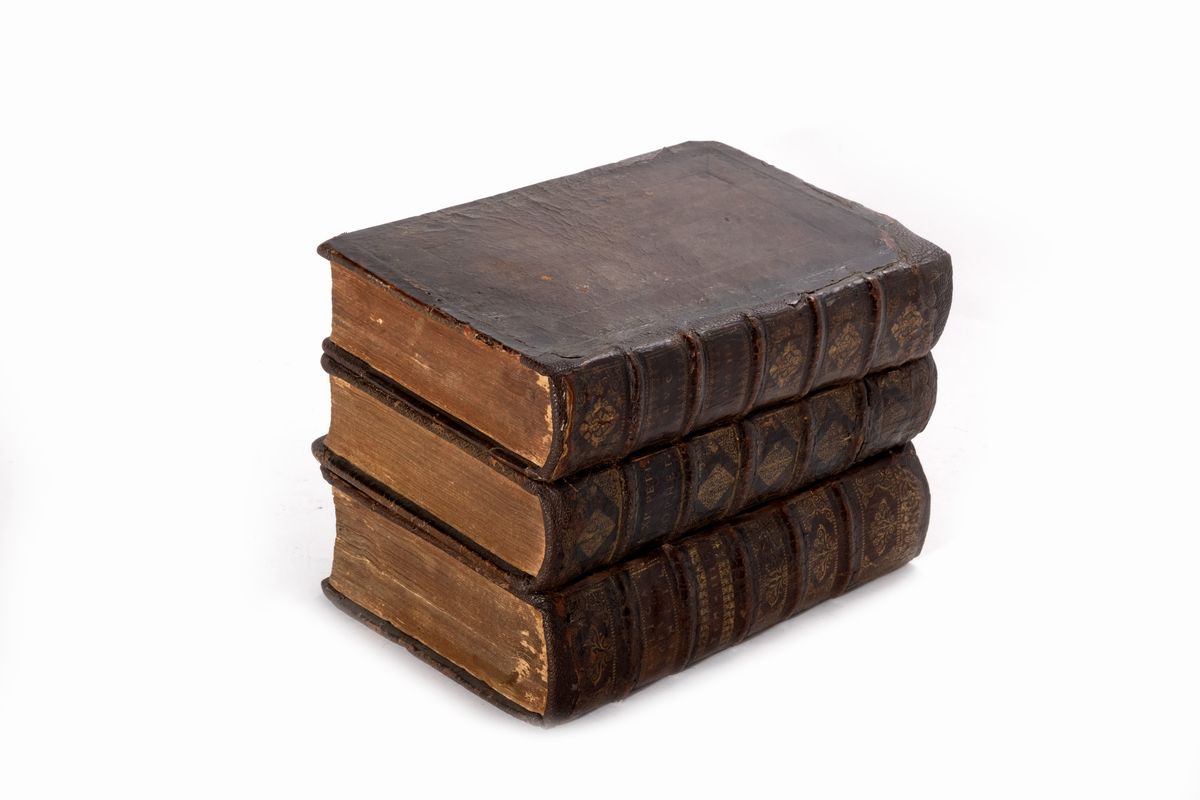 Contenitore a forma di libro con due fiaschette in vetro decorate in oro e otto bicchierini in ar...