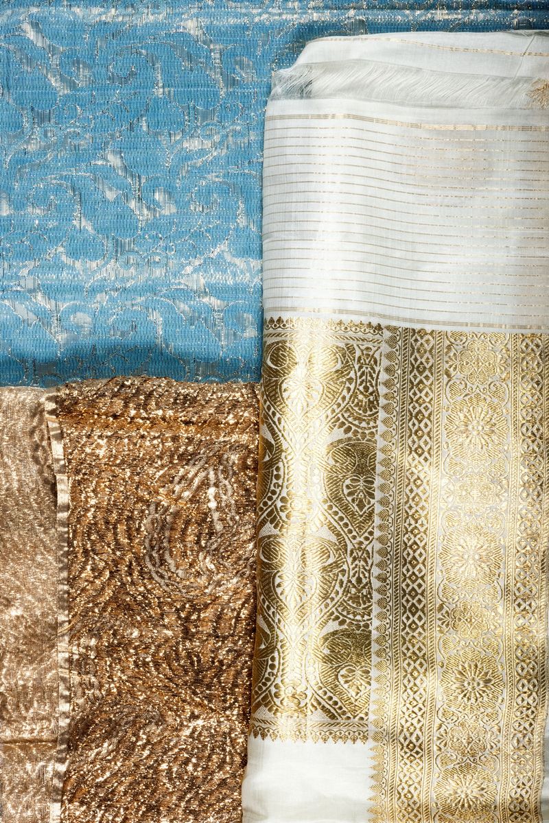 Lotto di tre tessuti indiani in seta, tonalità bianco, blu e dorato, con camicia rosa e tunica co...