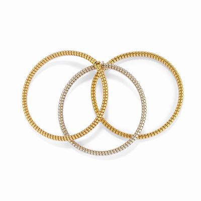 Tre bracciali in oro bicolore 18k, realizzati a tubogas con maglia elasticizzata