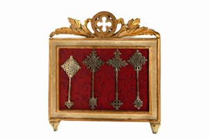 Lotto composto da quattro antiche croci etiopi in metallo argentato, entro cornice lignea laccata e dorata