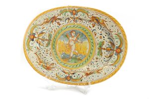  - Oval dish in polychrome majolica decorated with grotesques and Cupid in the centre